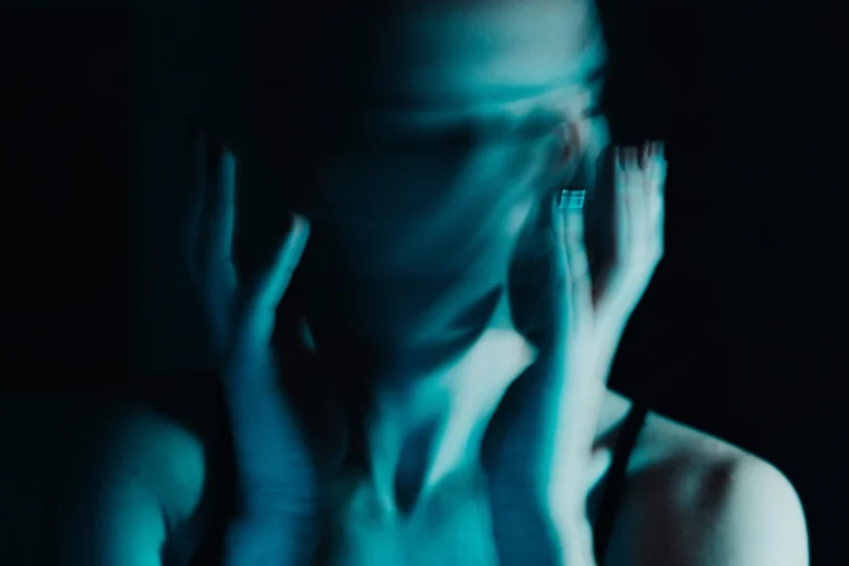 Motion-blurred portrait of a woman in blue lighting illustrating ADHD and emotional dysregulation.